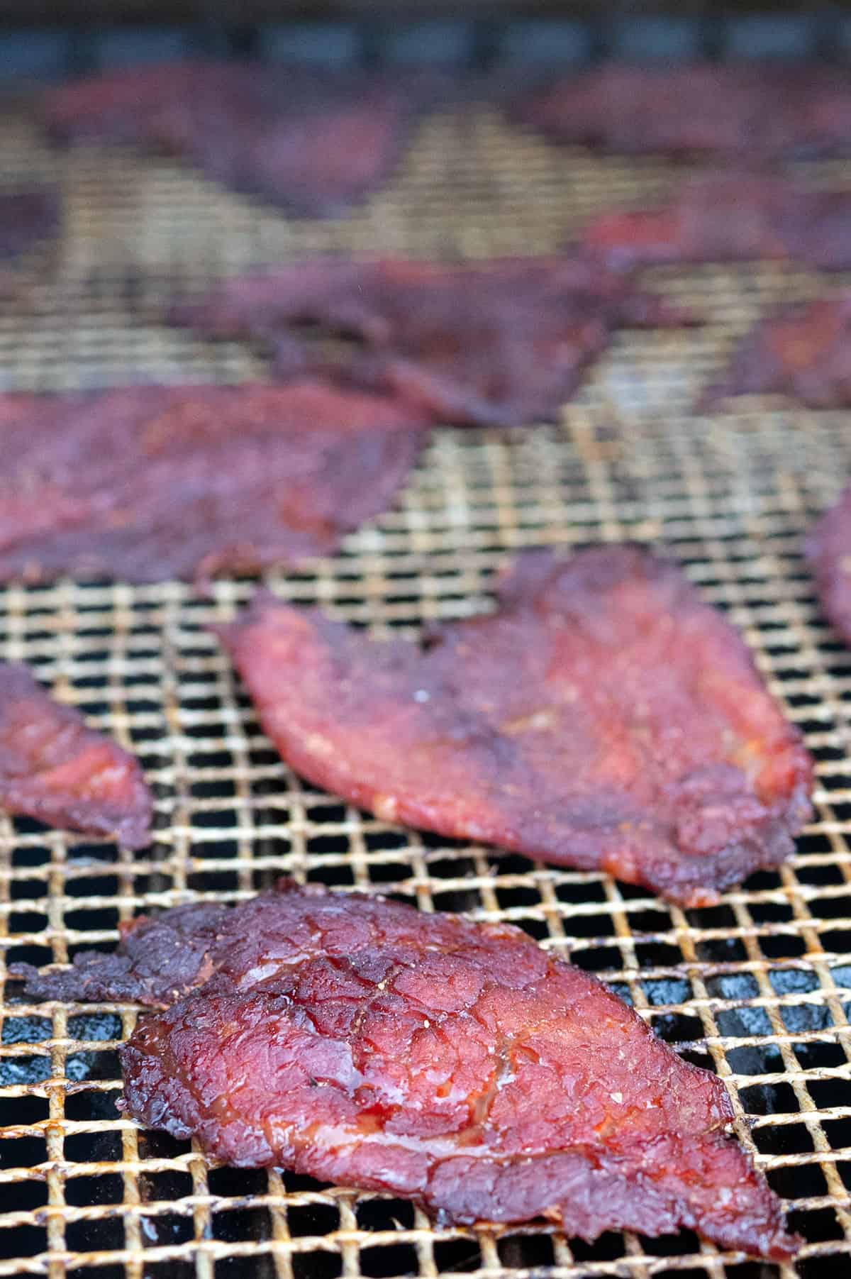 Smoked beef jerky on grill.