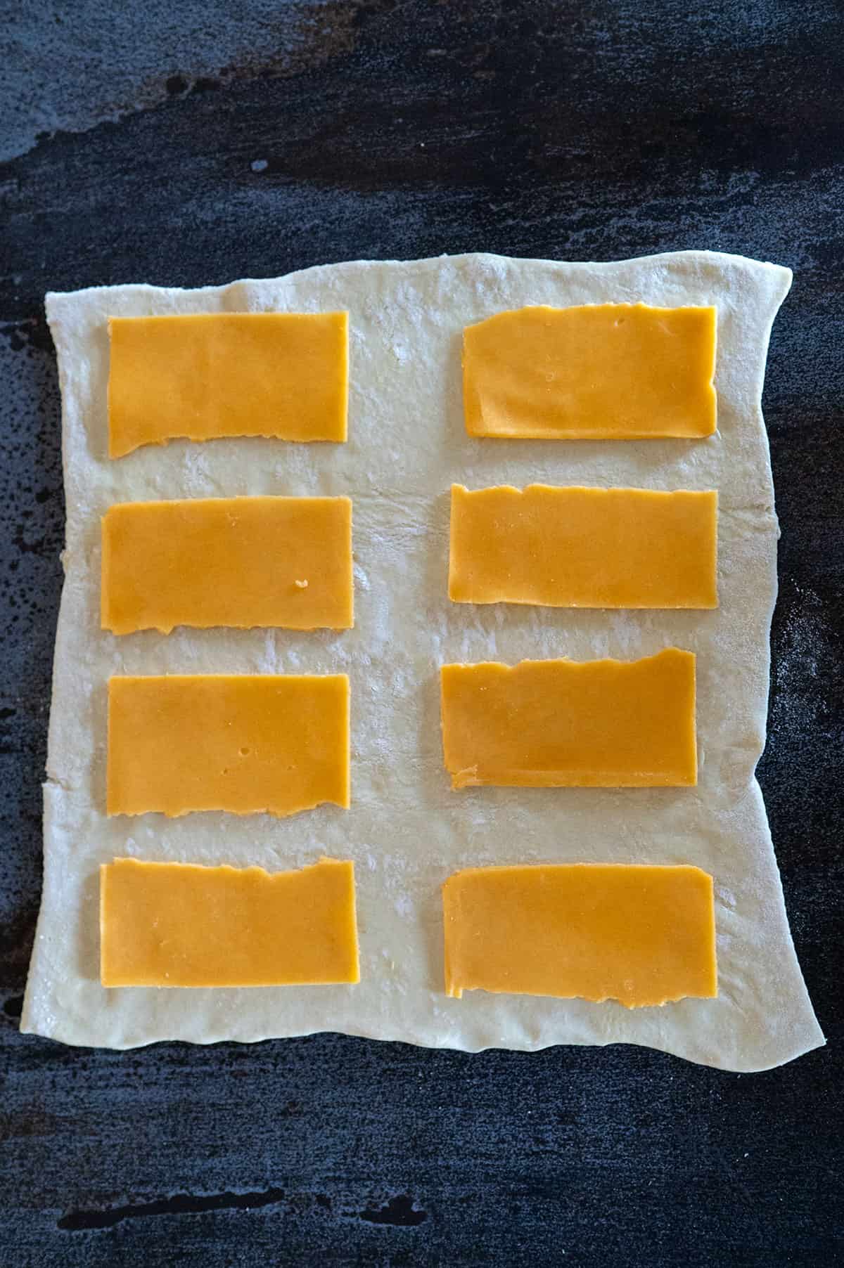 eight half cheese slices on puff pastry.
