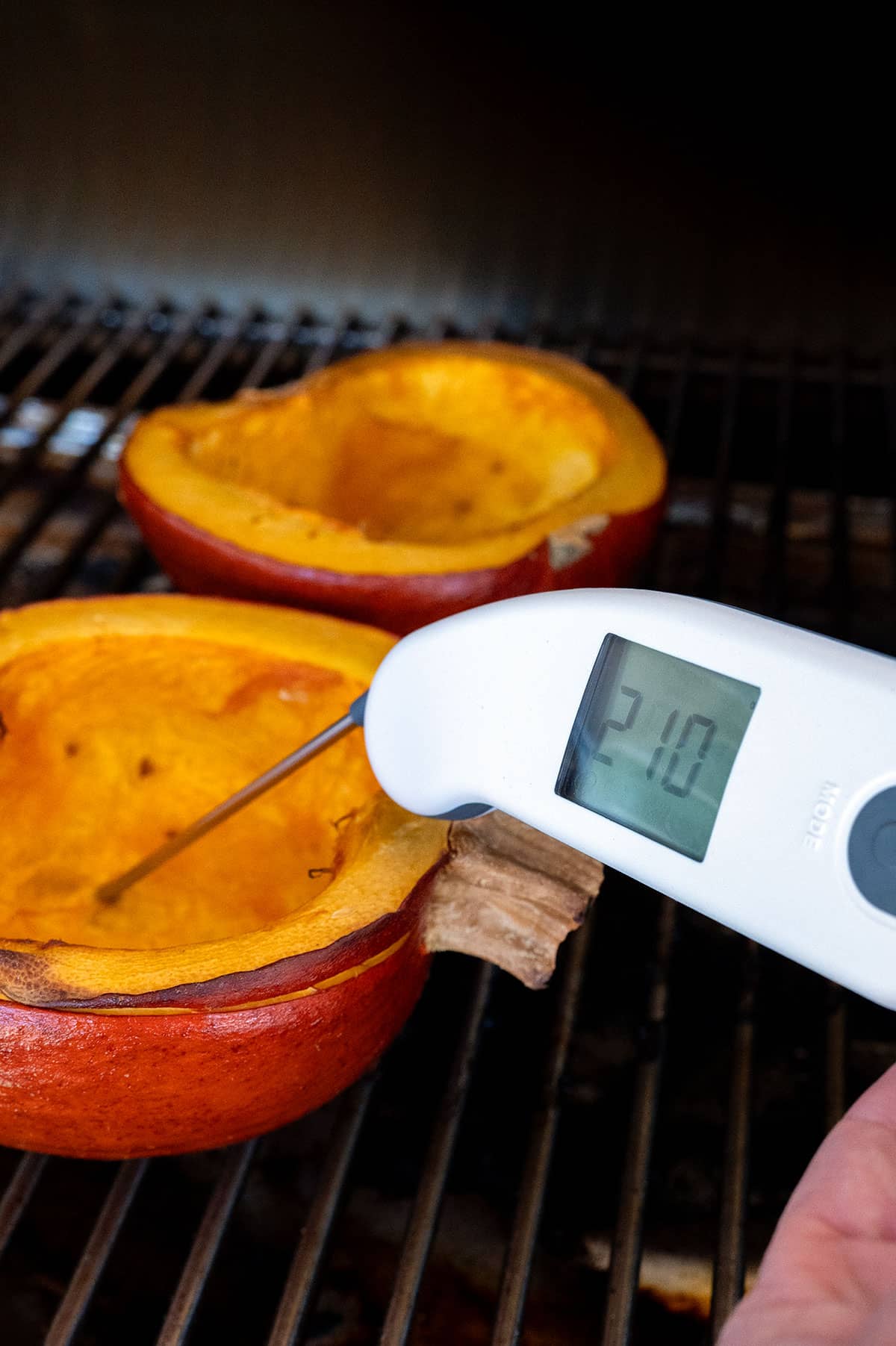Digital thermometer showing internal temperature of pumpkin at 210F degrees.