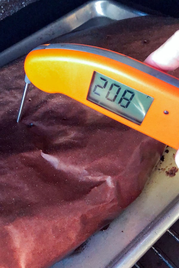 Thermometer showing wrapped brisket at 208F degrees.