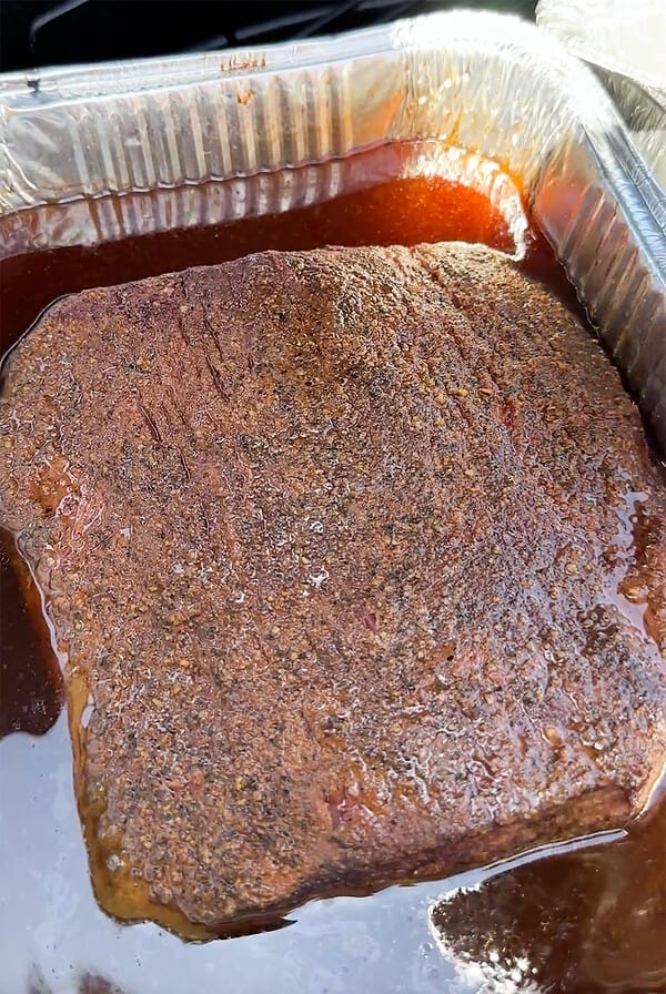 Brisket cooked hot and fast in pan with mop.