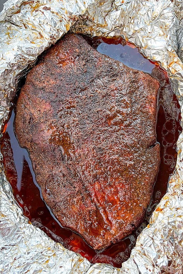 Smoked brisket unwrapped from foil wrap.