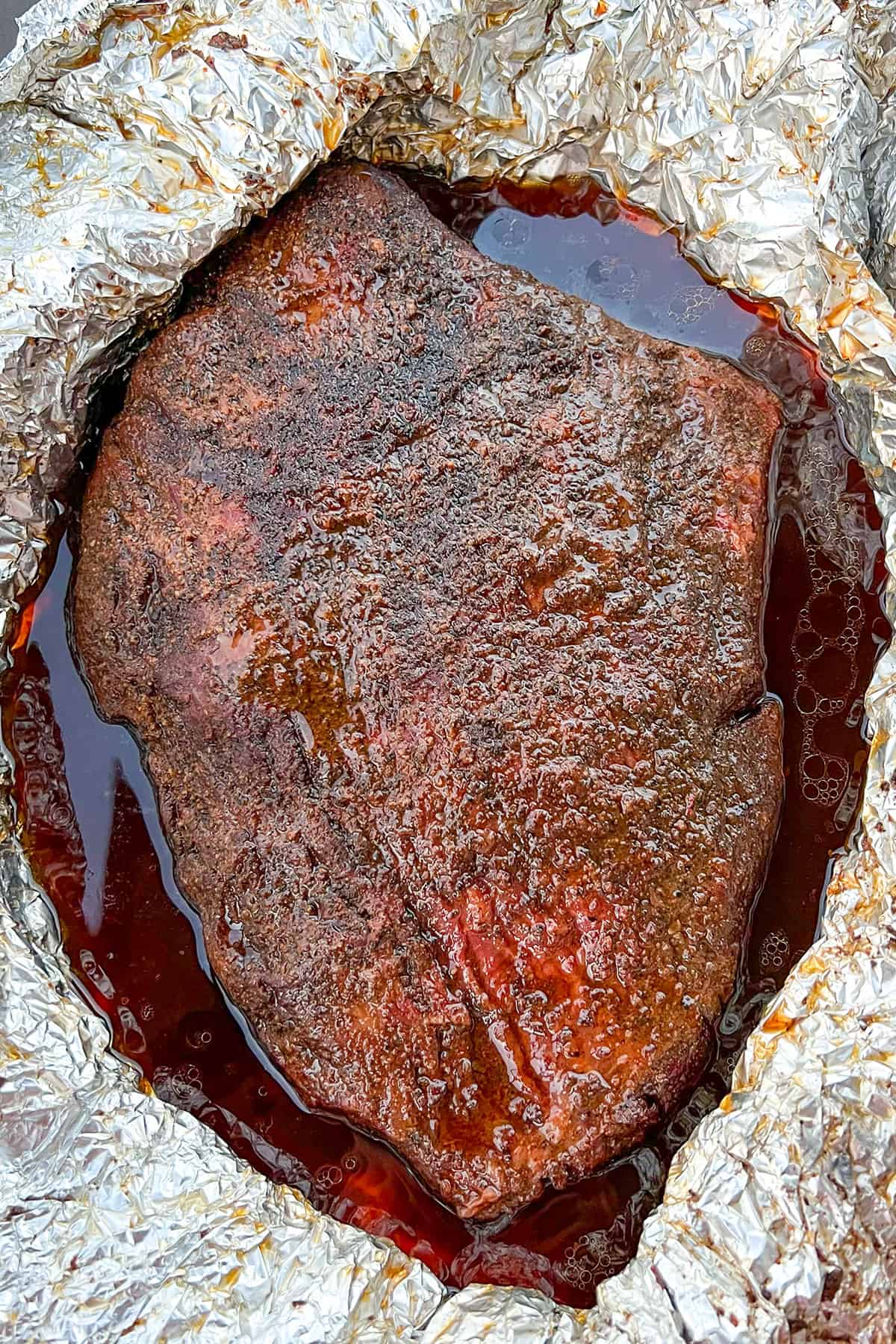 Smoked brisket unwrapped from foil wrap. 