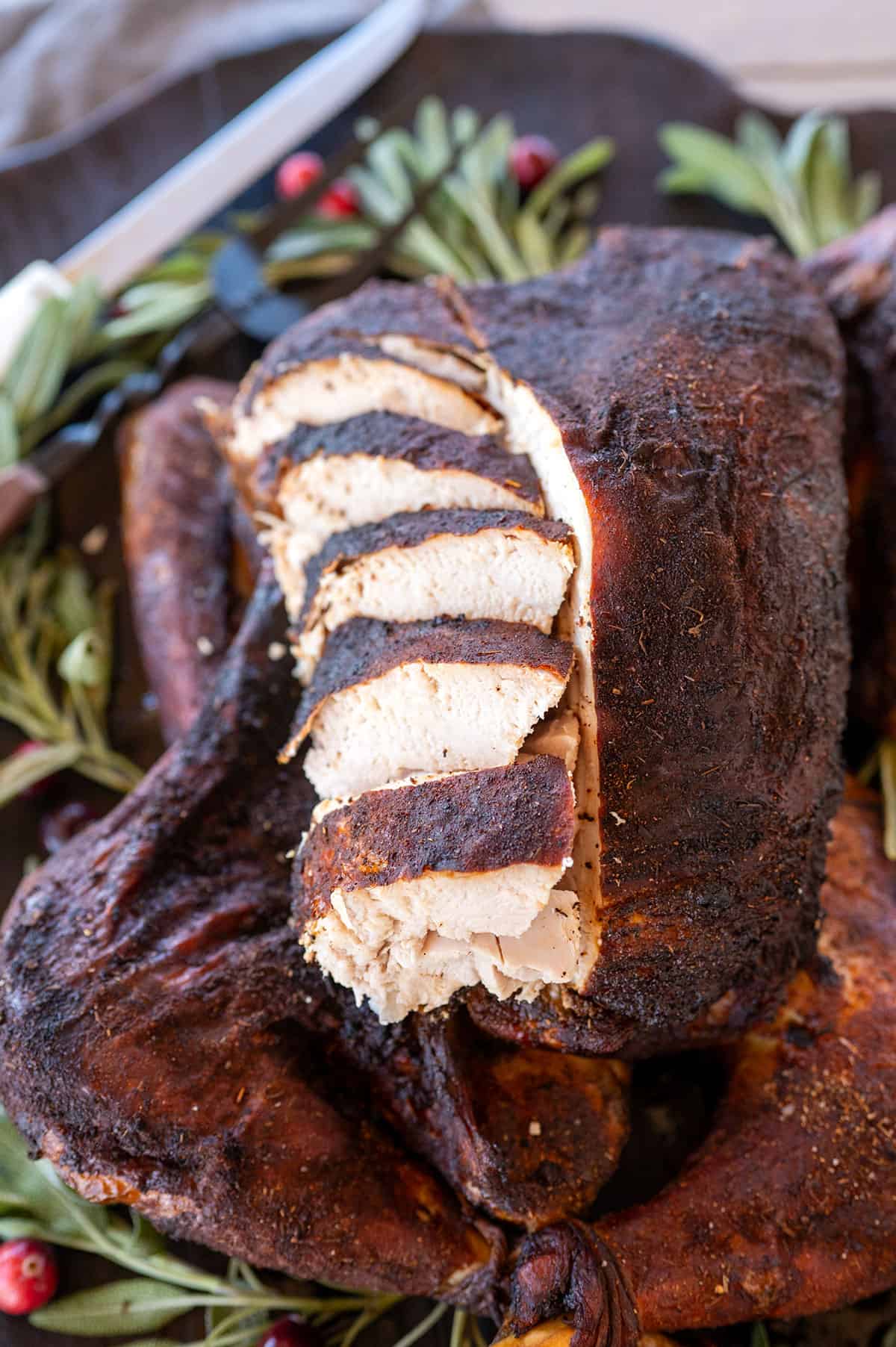 Sliced turkey breast laid back on smoked turkey.