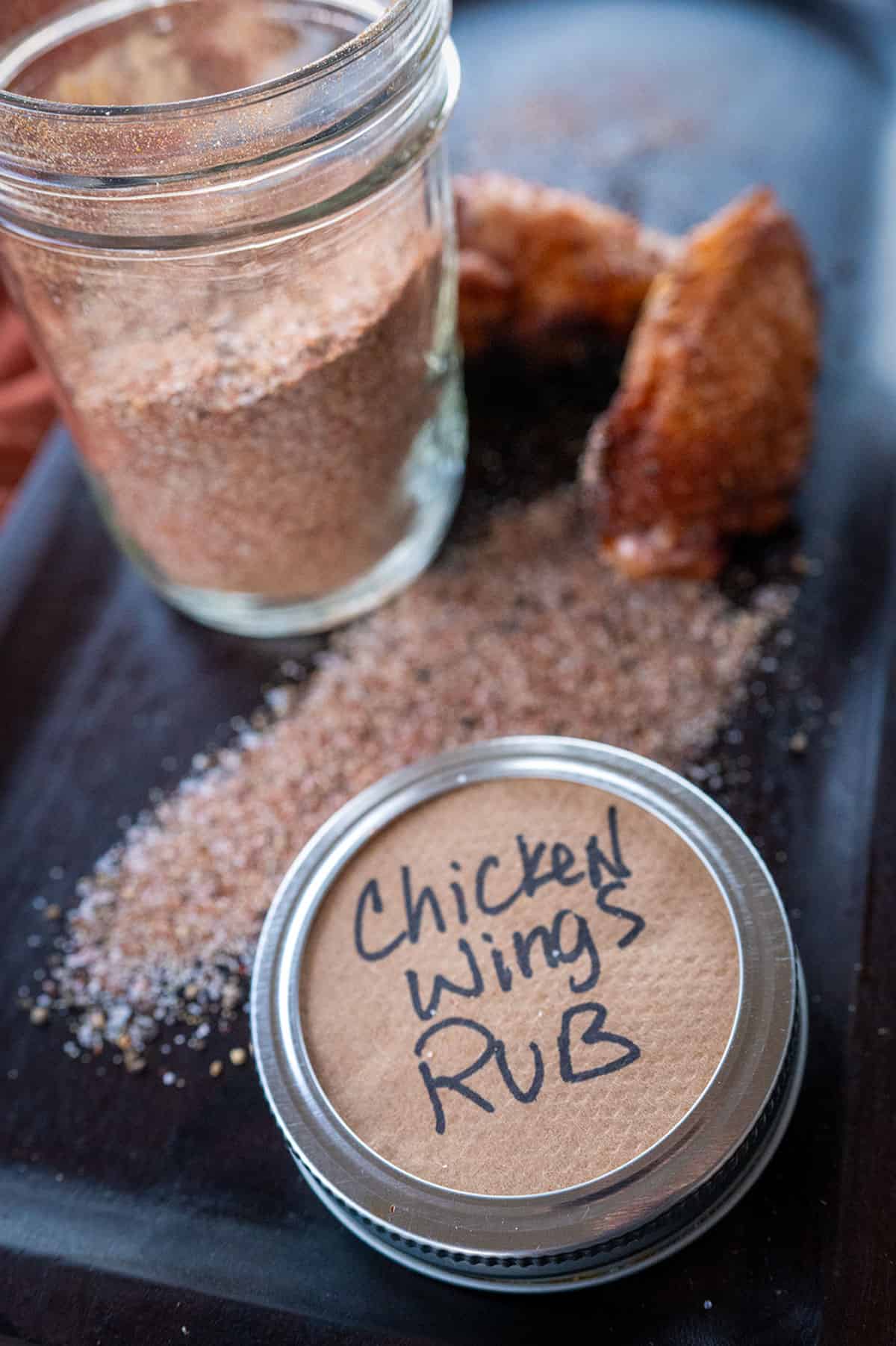 Chicken wing rub on platter with two smoked wings.