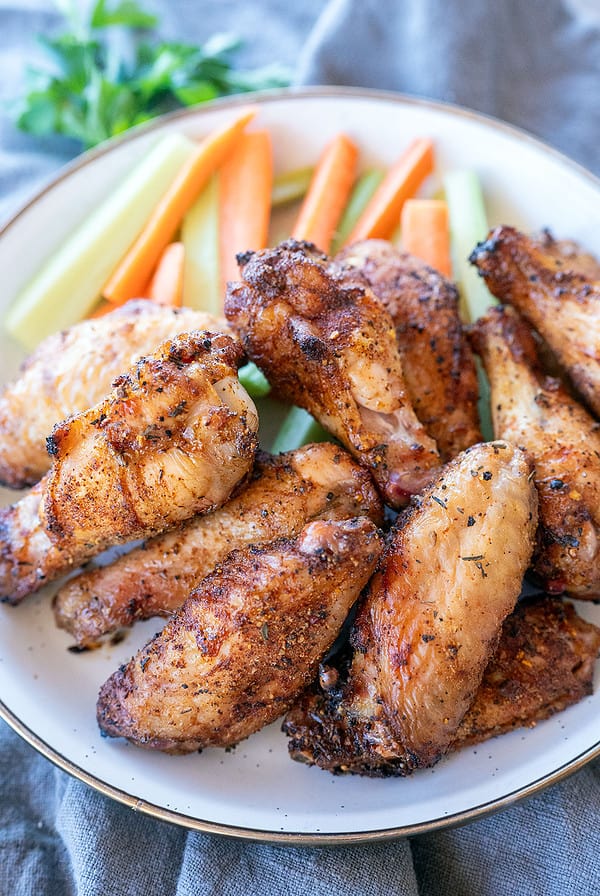 plate of chicken wings with carrots and celery.