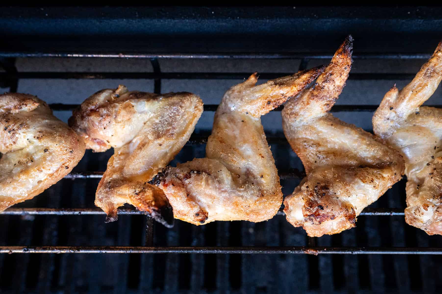 Crispy chicken wings on grill skin down.