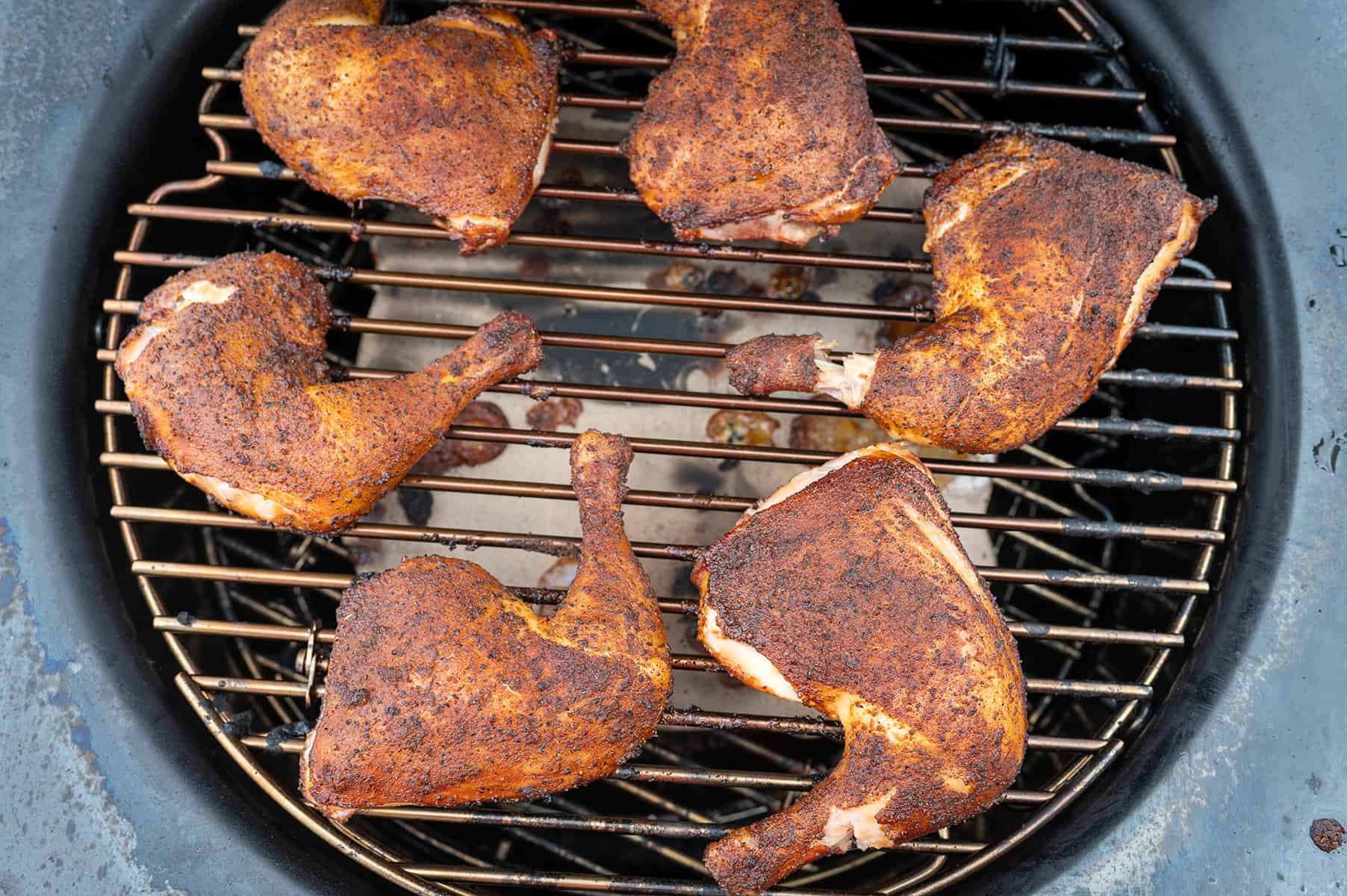 Smoked chicken quarters on grill.