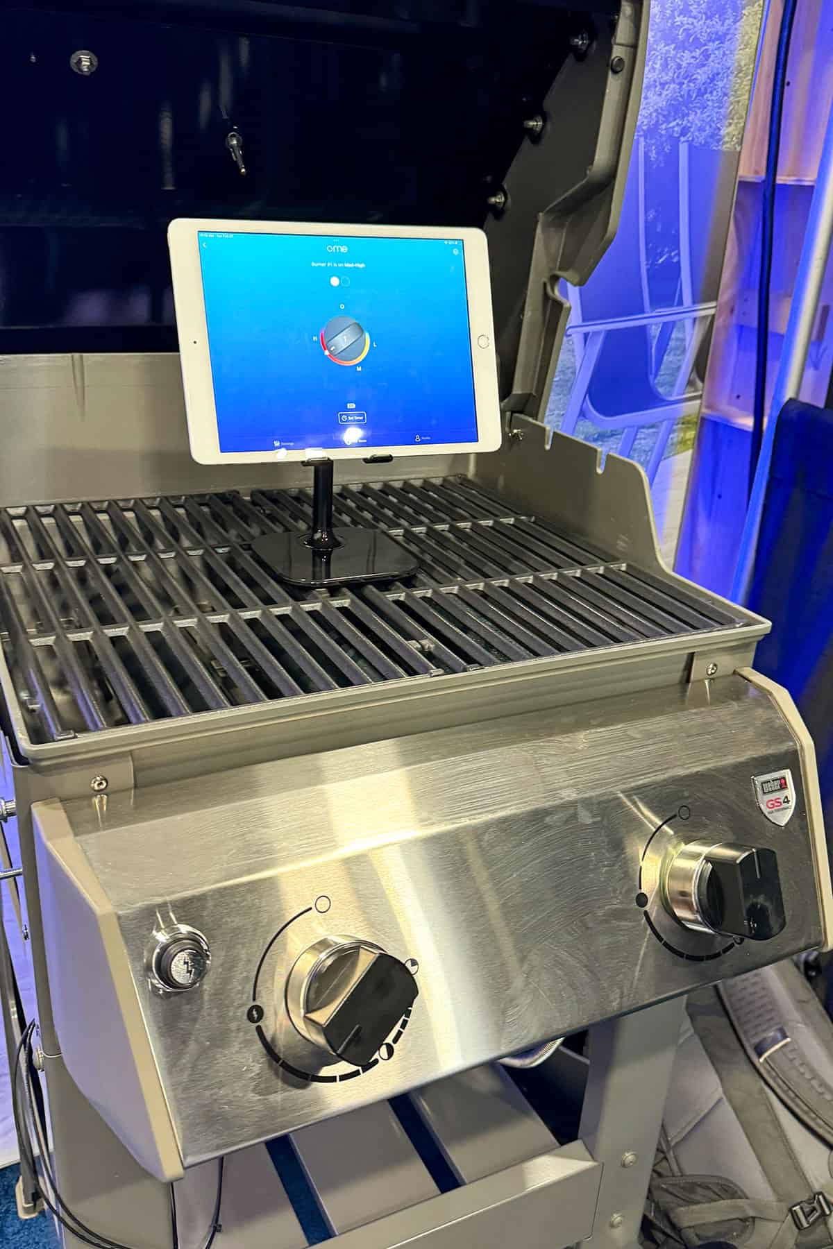 Ome Kitchen Knob on gas grill with tablet showing app.