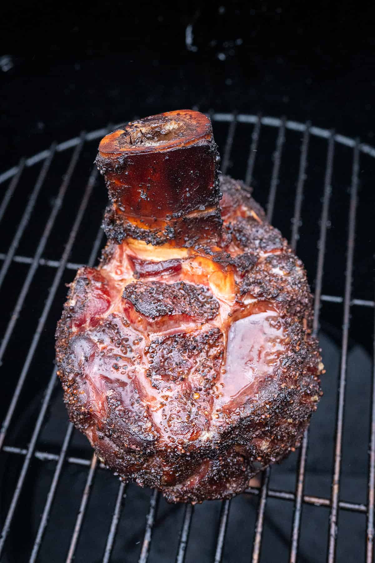 Beef shank smoking on grill.