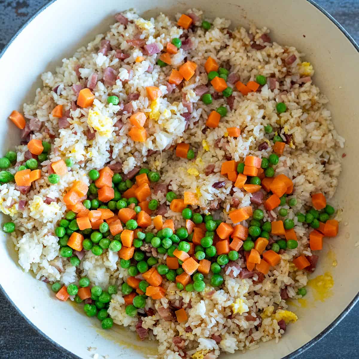 Peas and carrots added to fried rice.