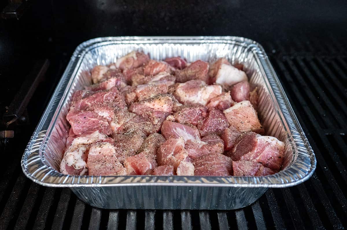 seasoned pork butt in pan on grill.