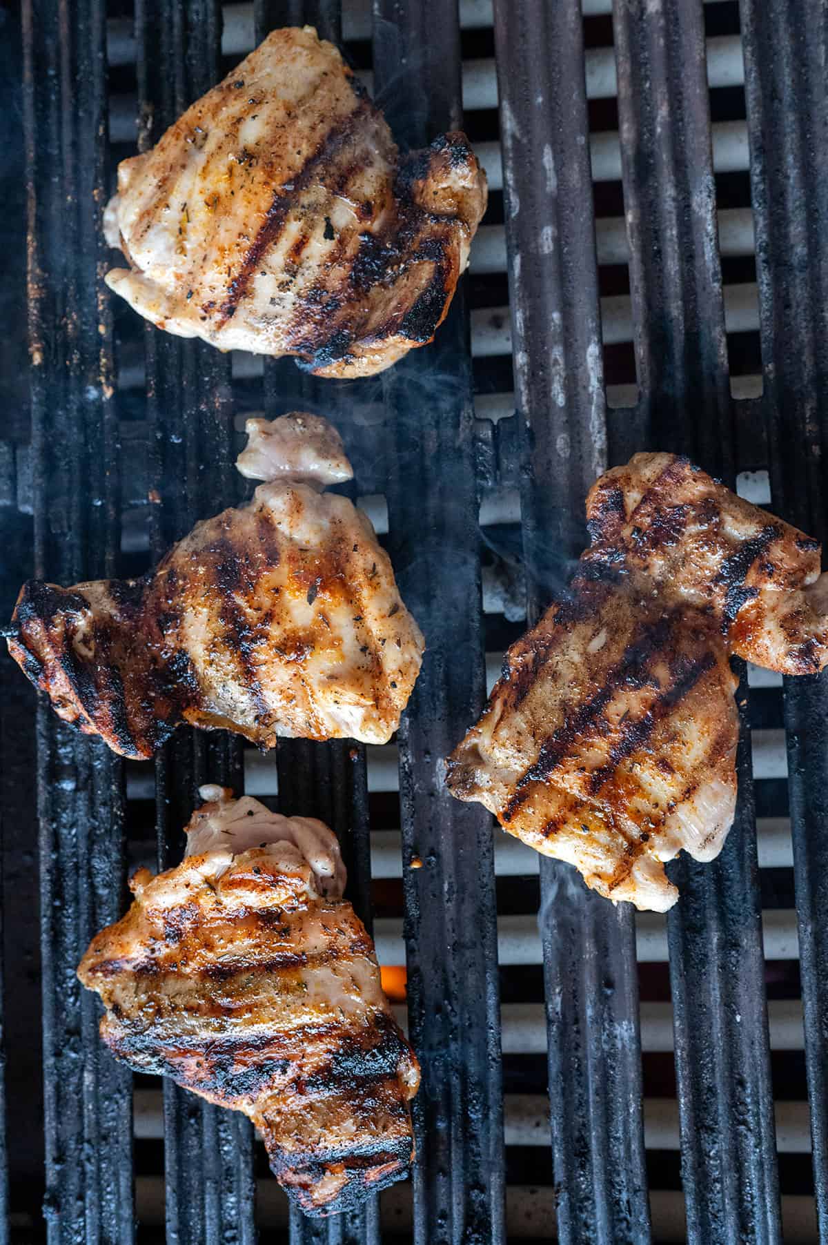 four boneless chicken thighs on grill.