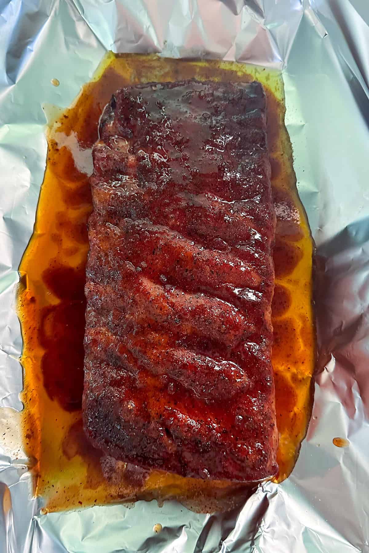 ribs on foil with liquid.