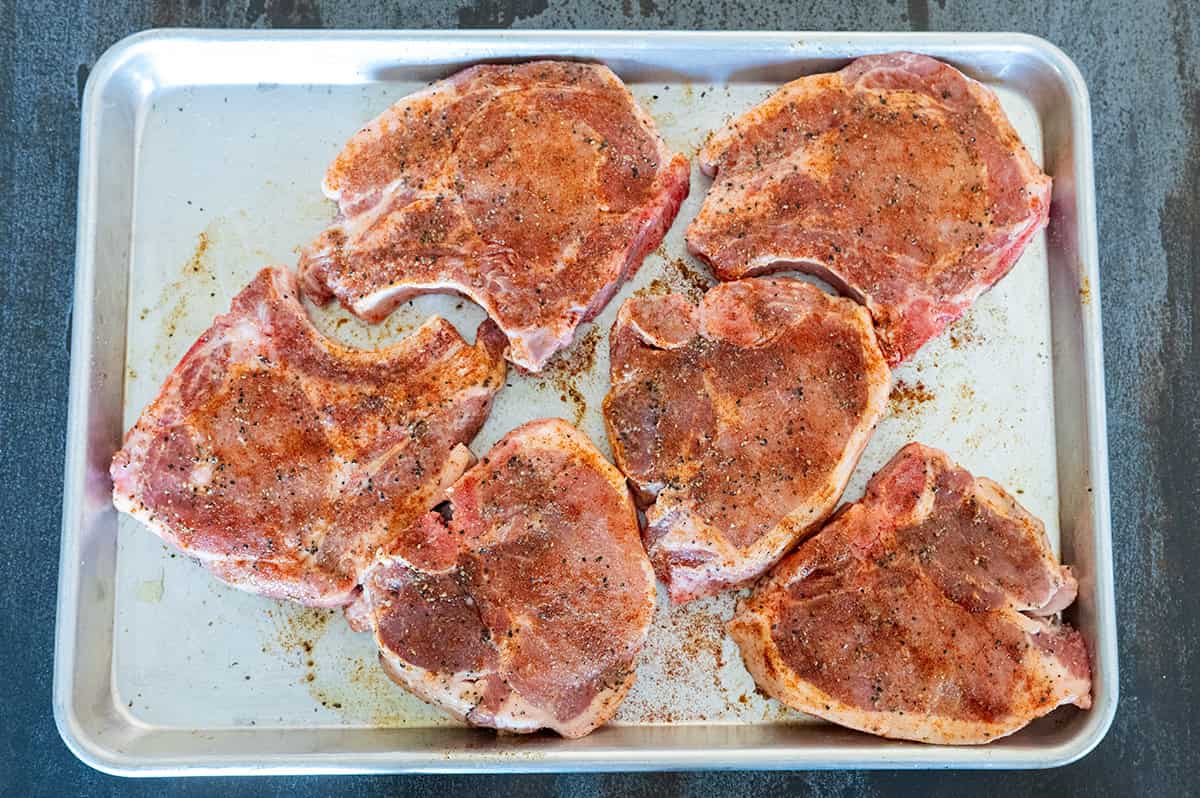 Pork chops on pan seasoned.
