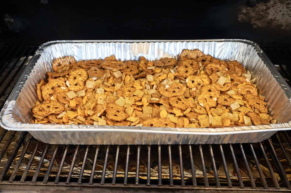 Smoked Chex Mix in pan on grill.