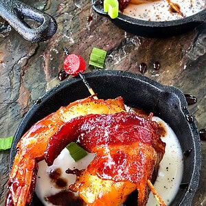 Ancho Glazed Bacon Wrapped Shrimp in pan with ranch dressing.