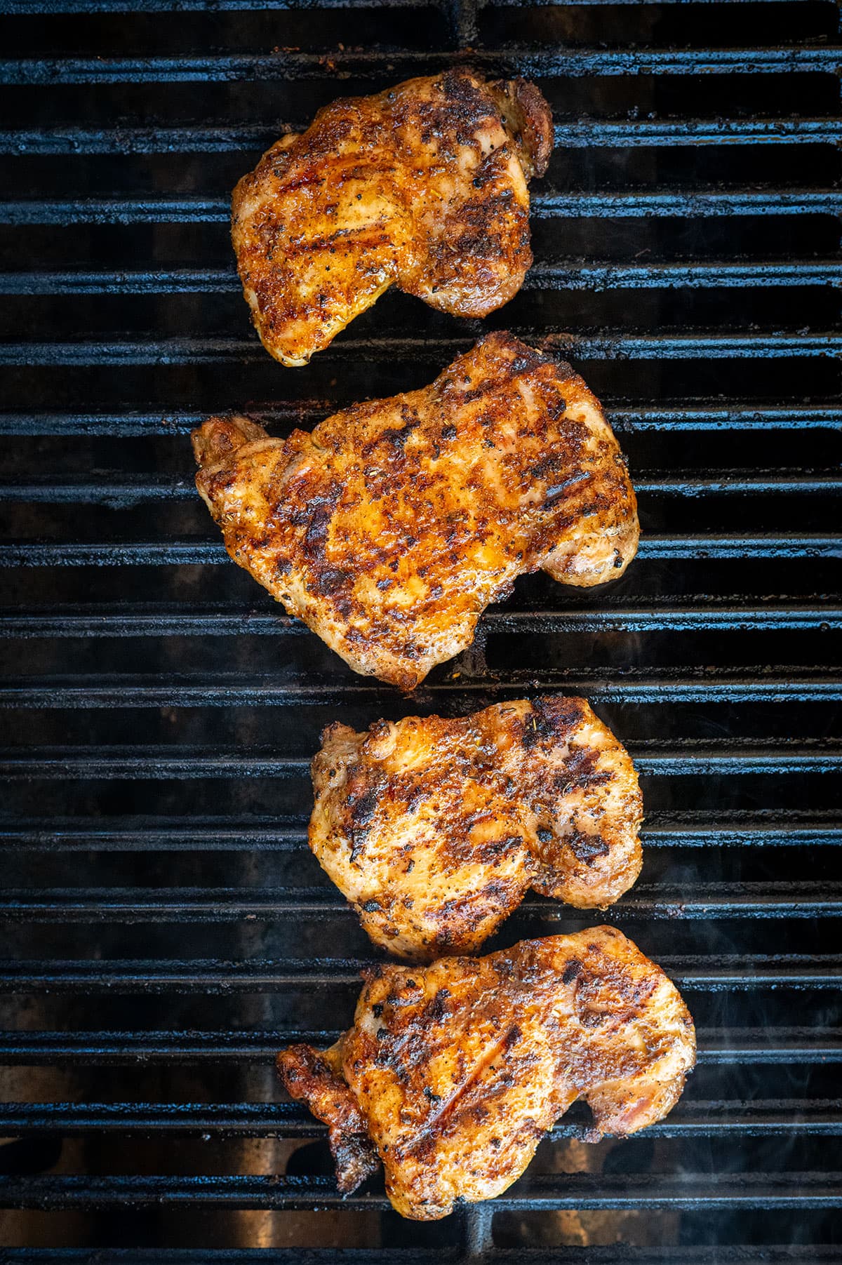 Cooked chicken thighs on grill.