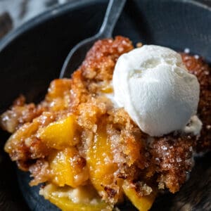 Serving of peach cobbler with ice cream.