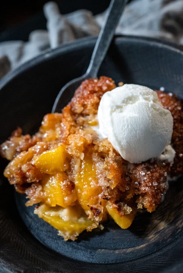 Serving of peach cobbler with ice cream.