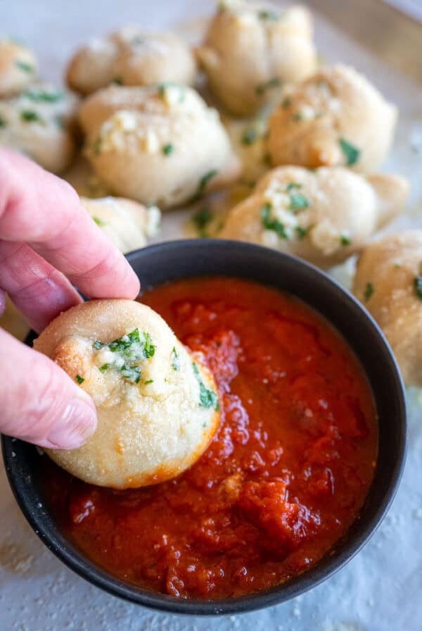 dipping garlic knot in marinara.