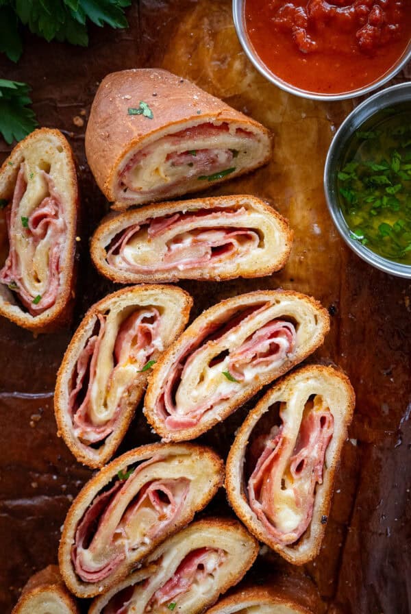 Sliced stromboli with dipping sauces.