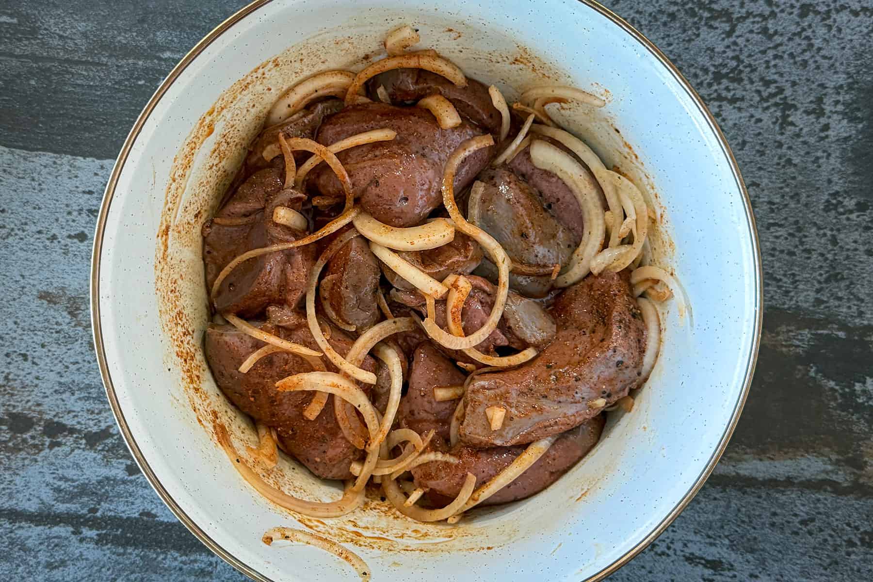 Liver marinating in bowl.