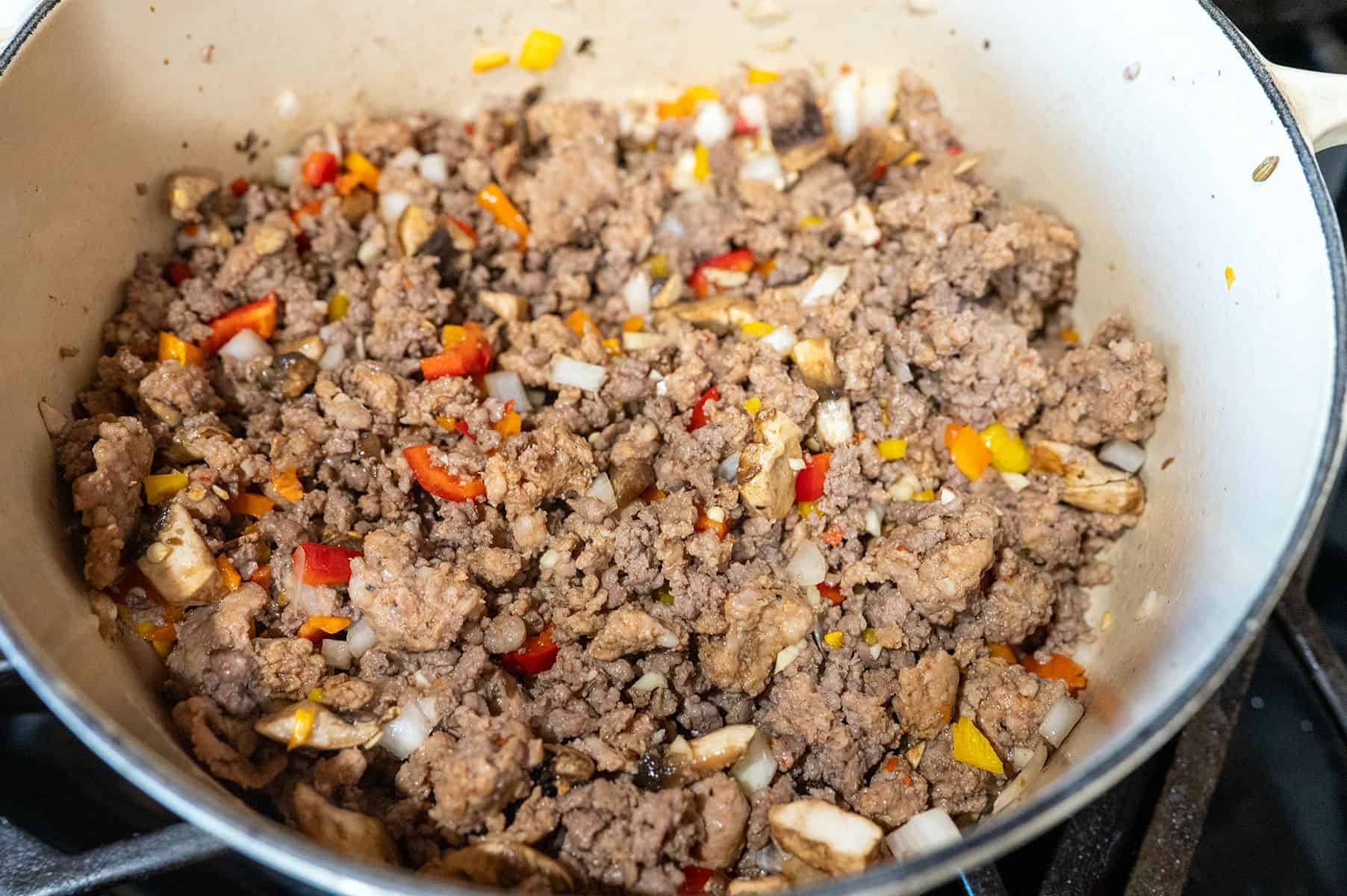 browned ground beef and sausage with peppers and onions.