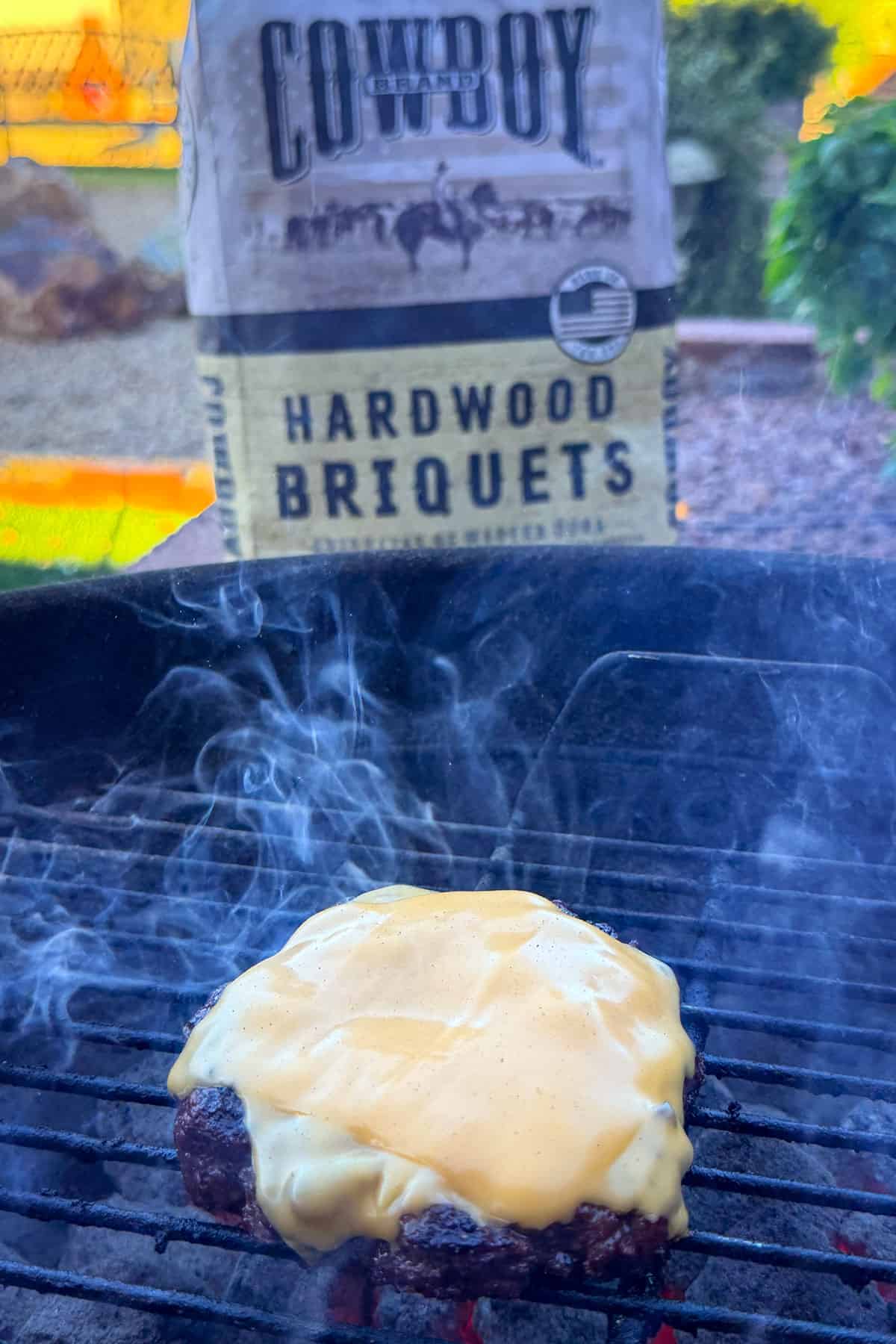 Burger grilling with cheese melting.