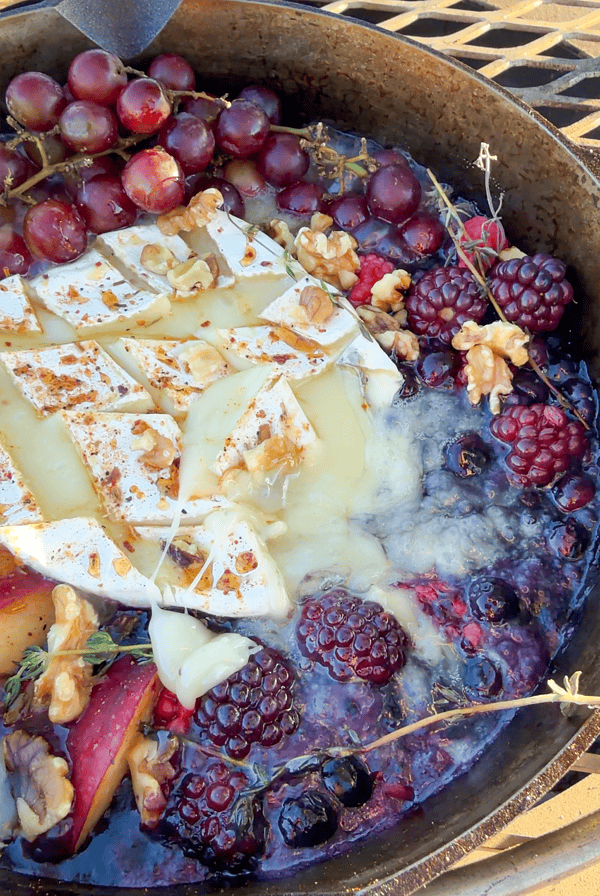 Campfire brie cheese dip with berries.