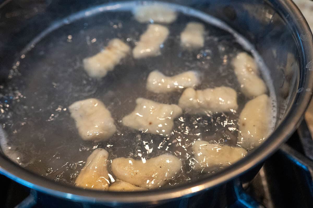Grilled Gnocchi floating in water.