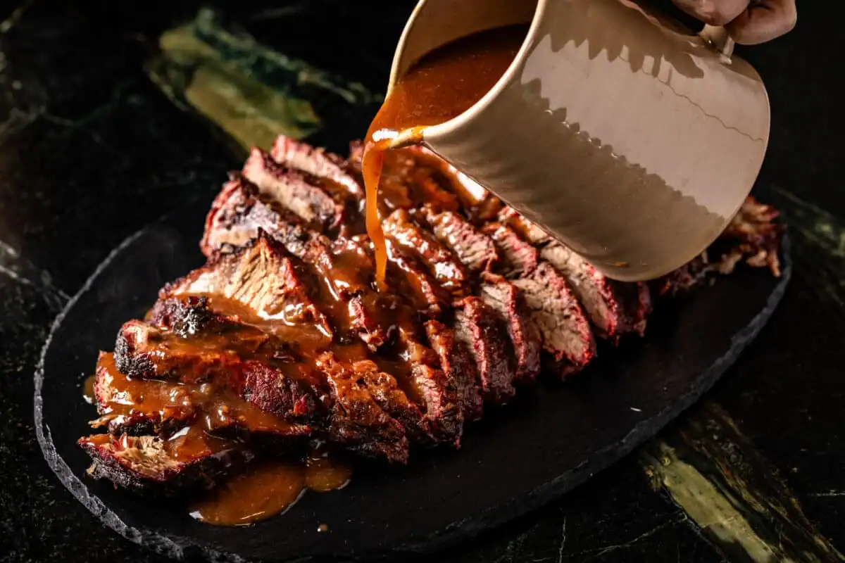 Pouring sauce over smoked sauerbraten.