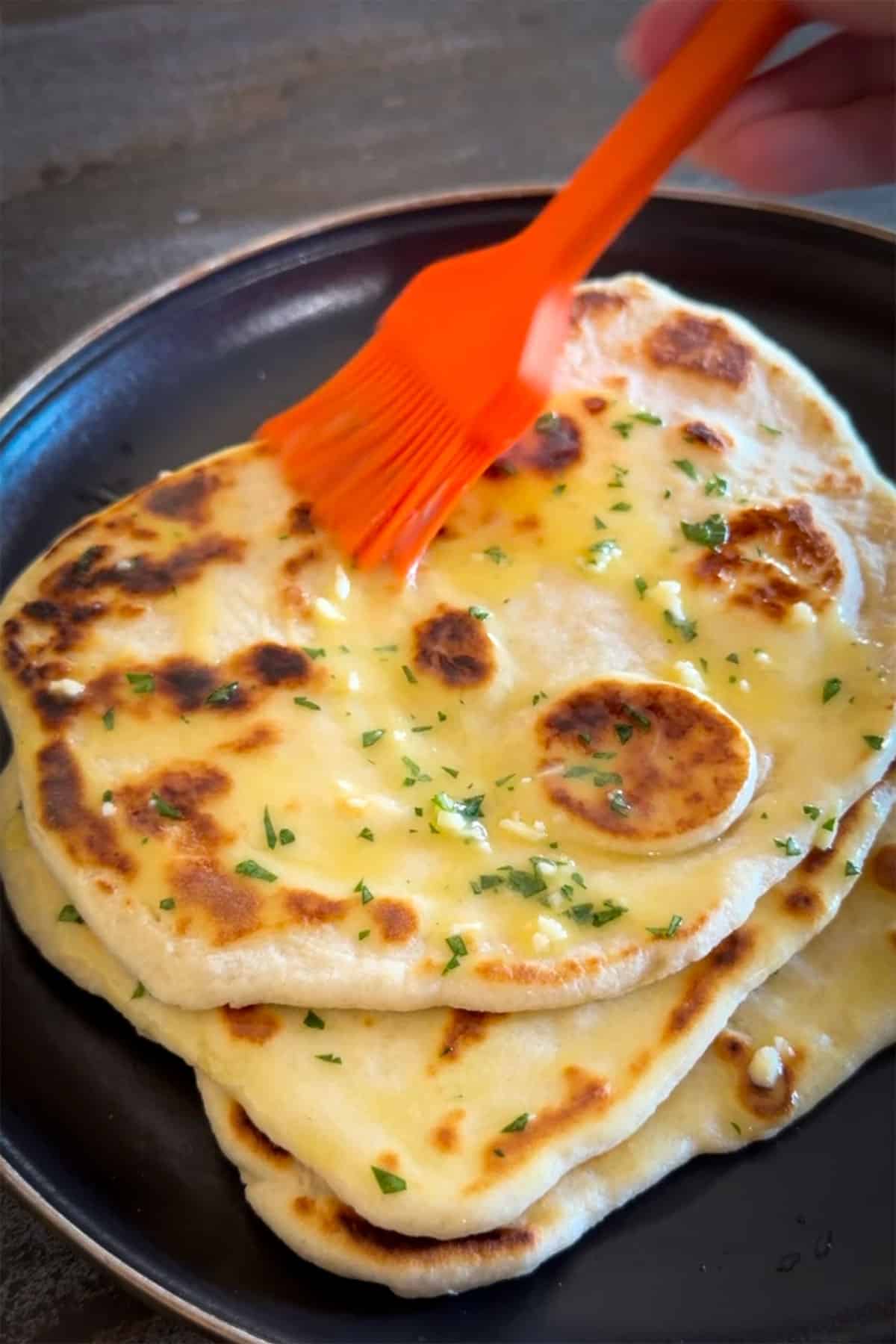 Brushing butter on flatbread.