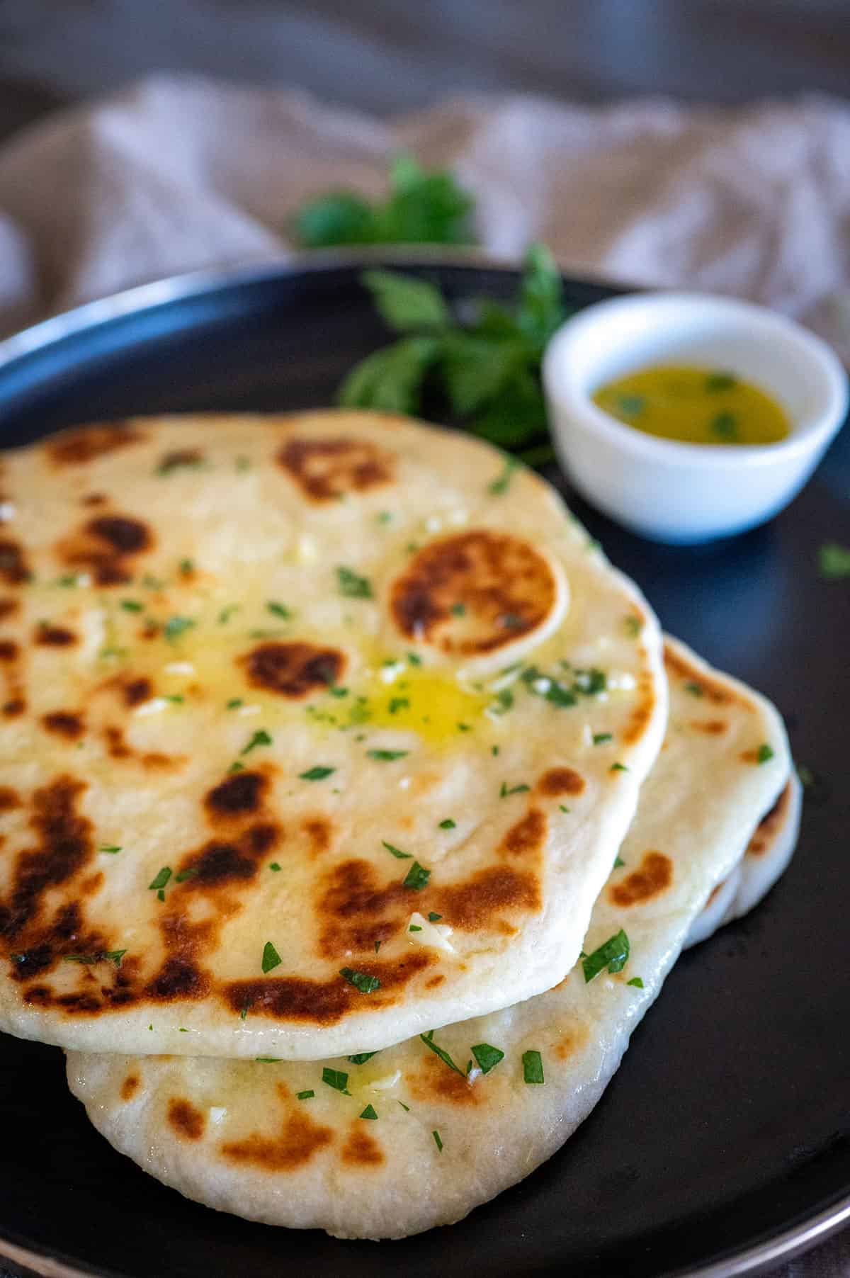 Plate of flatbread with butter and herbs.