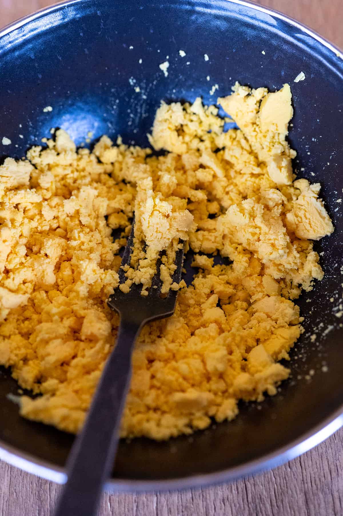 Mashing hard boiled egg yolk with a fork.