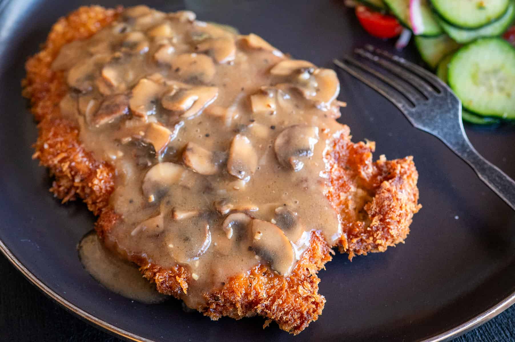 Plate of pork schnitzel with gravy.