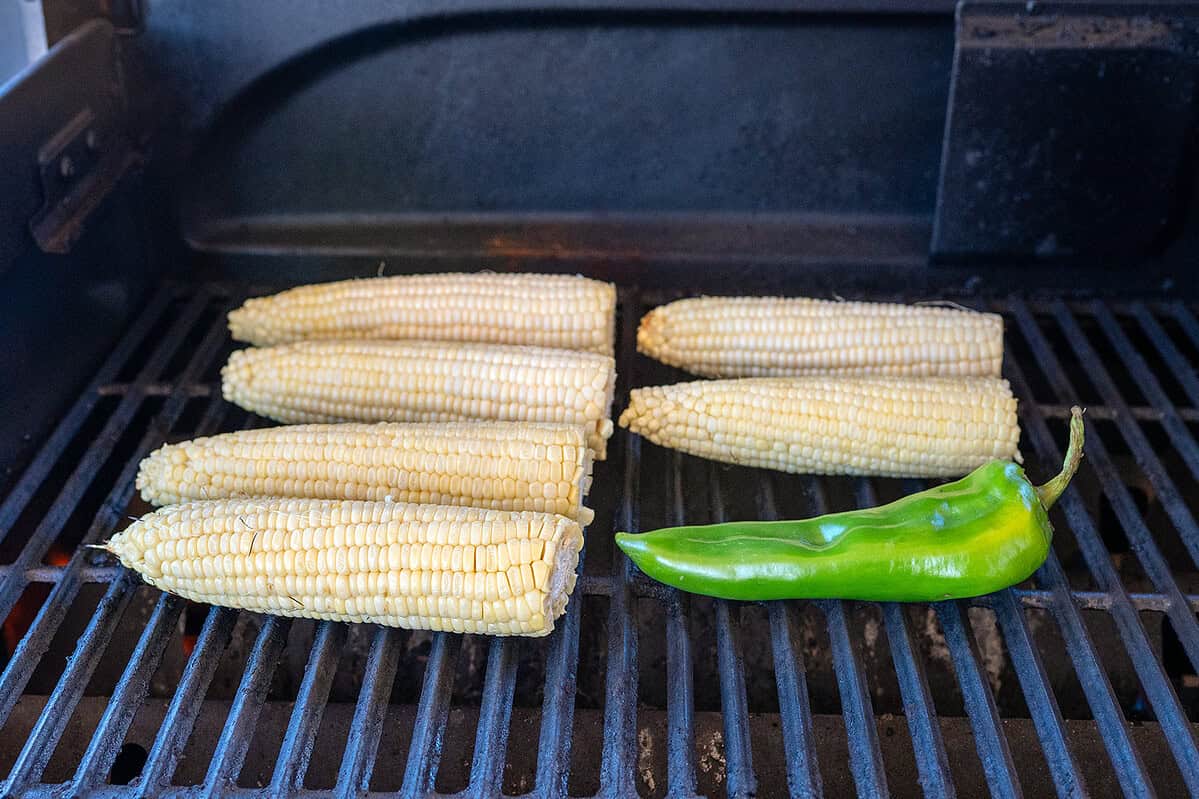 Raw corn and green chile on grill.