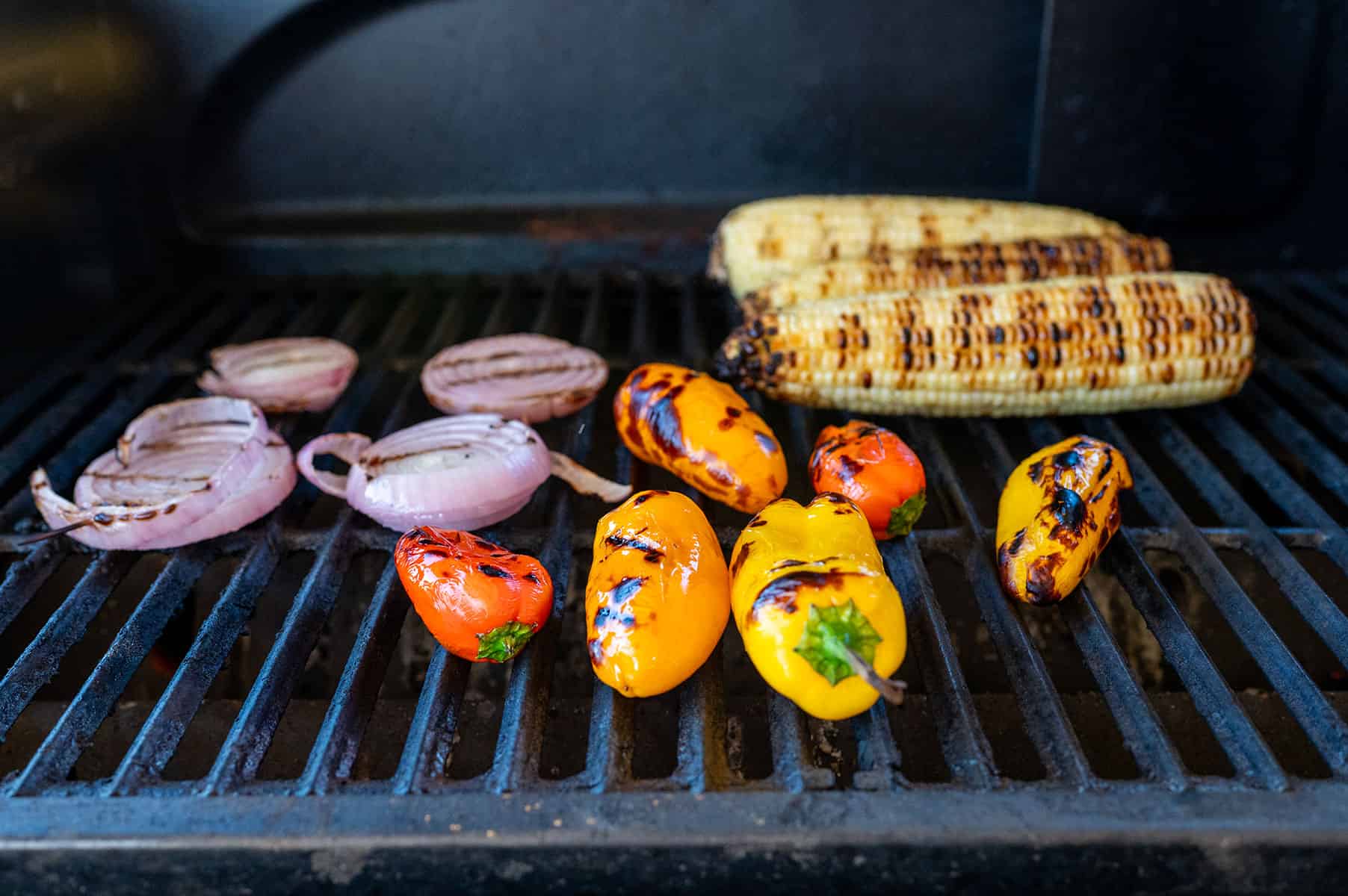 corn, peppers and onions on grill.
