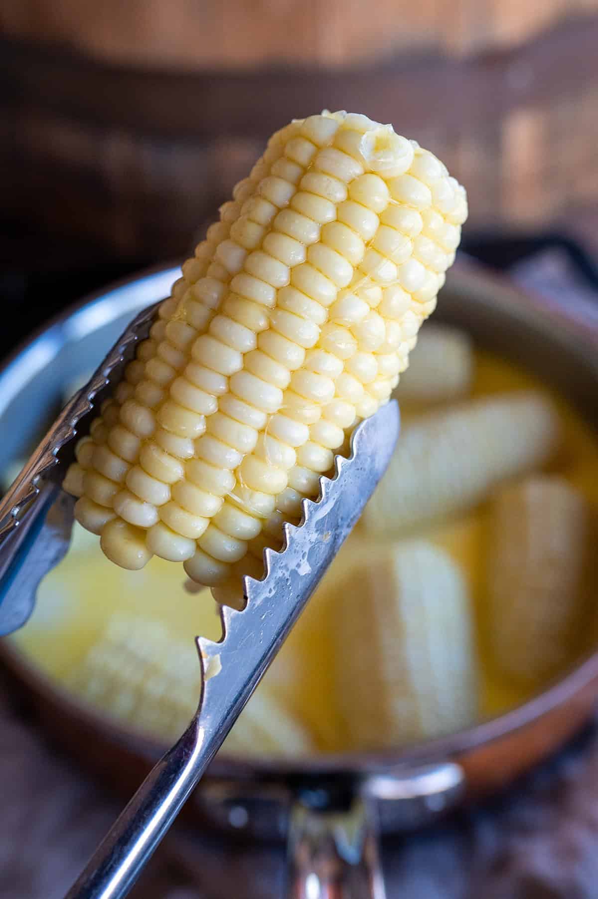 Tongs holding corn.