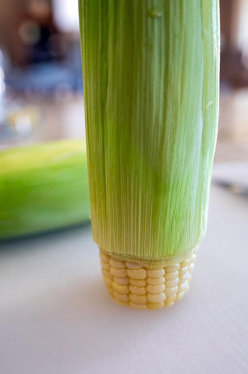 Sliding husk off corn.